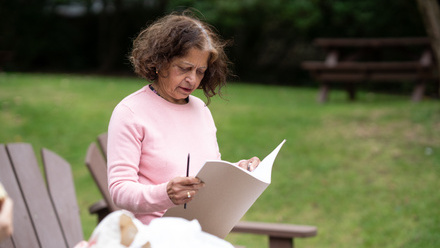 women in the park reading a leaflet